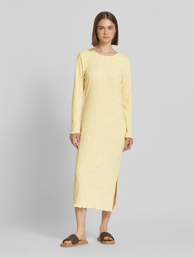 Frauenmodel trägt Tailliertes Freizeitkleid mit Allover-Muster Modell 'FLORA' von Pieces in Gelb mit floralem Crinkle-Stoff, Ganzkörperansicht von vorne.