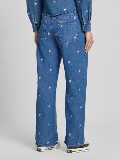 Frauenmodel trägt Loose Fit Wide Leg Jeans aus reiner Baumwolle Modell 'VEGA' von Only, Denim-Optik, Motiv-Stitching, Rückansicht.