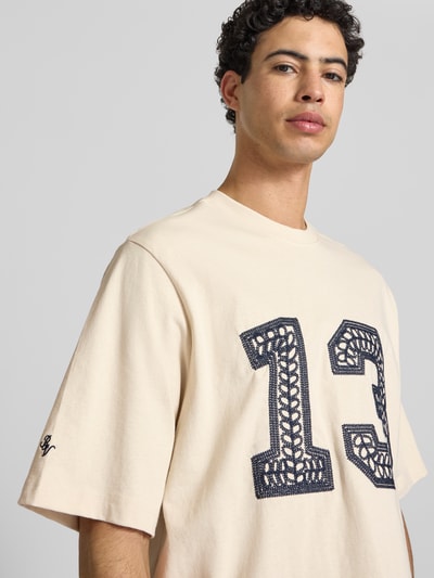 Männermodel trägt T-Shirt mit Ketten-Stickerei und Rundhalsausschnitt von REVIEW, Reine Baumwolle, Relaxed-Fit, Nahaufnahme Oberkörper. Rückenlänge bei Größe M: 65 cm.
