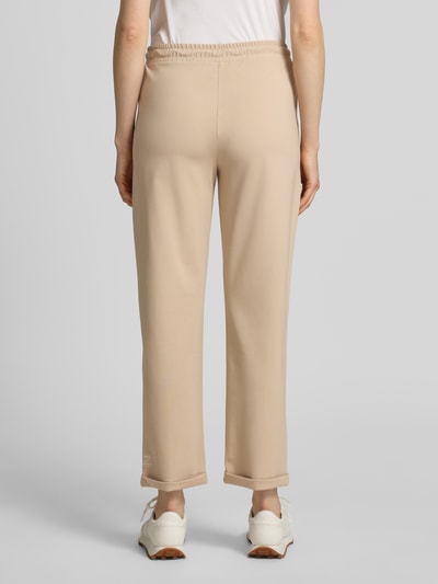 Vrouwenmodel draagt Straight Fit stoffen broek met siernaden van Marc Cain, mix van katoen en modal, 7/8-lengte, band met tunnelkoord, pijpboord, geheel van achteren.
