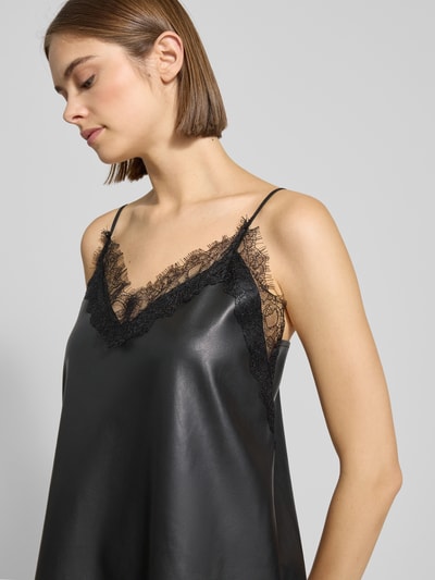 Frauenmodel trägt Regular Fit Minikleid mit Spitzenbesatz in Leder-Optik von Gina Tricot, Schwarz, verstellbare Spaghetti-Träger, Nahaufnahme Oberkörper.