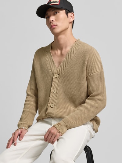Männermodel trägt Regular Fit Cardigan im Used-Look von MM6 Maison Margiela aus reiner Baumwolle mit Knopfleiste, Logo-Detail, Nahaufnahme Oberkörper.