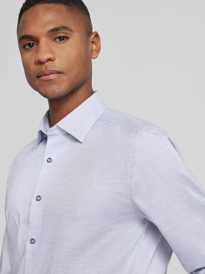 Männermodel trägt Slim Fit Businesshemd aus Baumwoll-Mix mit Kentkragen von OLYMP Level Five, hellblau, Nahaufnahme Oberkörper. Durchgängige Knopfleiste, Sportmanschetten, elastisches Material.