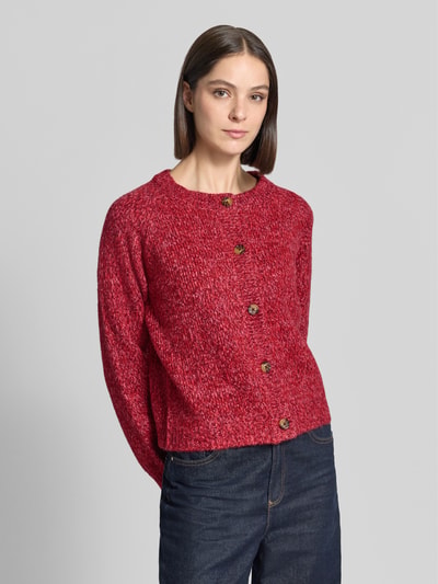 Frauenmodel trägt Relaxed Fit Strickjacke aus Woll-Mix Modell 'Nova' von LOLLYS LAUNDRY in Rot, grobe Textur, Ganzkörperansicht von vorne. Damen Strickjacke, durchgehende Knopfleiste, langärmelig, Rückenlänge 52 cm, Ärmellänge 47 cm.