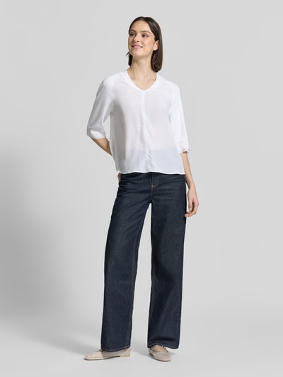Frauenmodel trägt T-Shirt mit V-Ausschnitt und 3/4-Arm von Marc Cain aus Baumwoll-Elasthan-Mix, Relaxed-Fit, Rückenlänge 60 cm, Ganzkörperansicht von vorne.