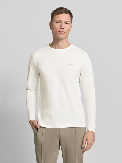 Männermodel trägt Longsleeve mit Rundhalsausschnitt und Logo von Fynch-Hatton, Reine Baumwolle, Regular-Fit, Unifarbenes Design, Ganzkörperansicht von vorne.