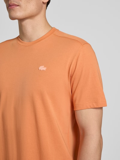 Männermodel trägt Regular Fit T-Shirt aus Baumwoll-Mix von Lacoste Sport, unifarben, Logo-Applikation, Nahaufnahme Oberkörper.