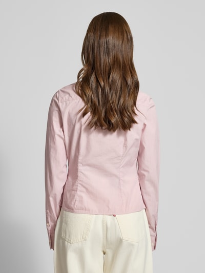 Frauenmodel trägt Slim Fit Hemdbluse aus reiner Baumwolle von Guess Jeans in Hellrosa, taillierte Passform, Ganzkörperansicht Rückansicht.