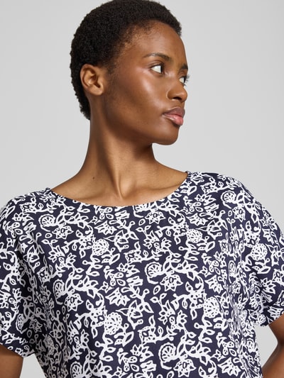 Vrouwenmodel draagt Relaxed Fit T-shirt uit zuiver viscose met all-over bloemenmotief, ronde hals van Christian Berg Woman, Nahaufnahme bovenlichaam.