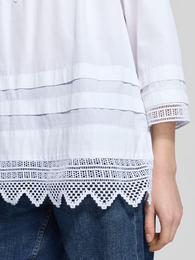 Frauenmodel trägt Oversized Bluse mit Lochspitze von Polo Ralph Lauren in Weiß, reine Baumwolle, detailreiche Textur, Nahaufnahme Oberkörper.