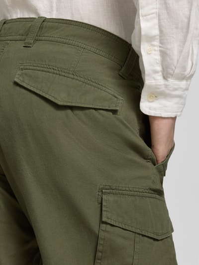 Męski model nosi Relaxed Fit Cargoshorts aus reiner Baumwolle Modell 'FILE' od s.Oliver RED LABEL, zielony, tekstura bawełny, detal tylu i bocznych kieszeni, detalaufnahme z tyłu.