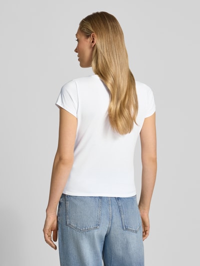 Frauenmodel trägt T-Shirt mit Label-Detail Modell 'LEOPARDTINI' von Guess in Weiß, körpernaher Schnitt, Rundhalsausschnitt, Baumwoll-Elasthan-Mix, Ganzkörperansicht Rückansicht.