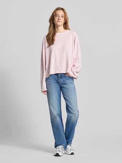 Frauenmodel trägt Straight Fit Jeans aus Baumwoll-Mix Modell 'SOPHIE' von Tommy Jeans in Denim-Optik mit Label-Patch, Logo-Stitching, 5-Pocket-Design, Gürtelschlaufen, Knopf und verdeckter Knopfleiste, Materialverarbeitung Twill, Ganzkörperansicht von vorne.