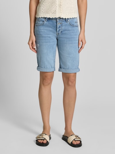 Frauenmodel trägt Jeansshorts im Destroyed-Look Modell 'Malibu' von Buena Vista aus Baumwoll-Mix mit Viskose-Anteil, Regular-Fit, hellblau, Bundweite bei Größe S: 36 cm, Innenbeinlänge bei Größe S: 28 cm, Ganzkörperansicht von vorne.