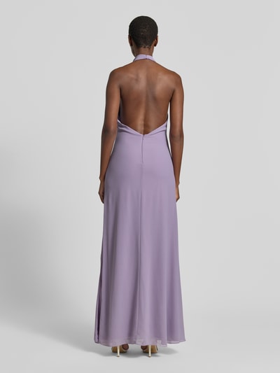 Frauenmodel trägt Abendkleid mit Neckholder von Mascara in Flieder, Chiffon, körpernah, Maxilänge, Rückenansicht, Ganzkörperansicht Rückansicht.