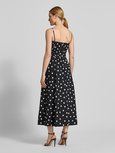 Frauenmodel trägt Midikleid mit Polka Dots Modell 'Eviana' von Forever New aus reiner Baumwolle, schwarze A-Linie, Ganzkörperansicht Rückansicht.