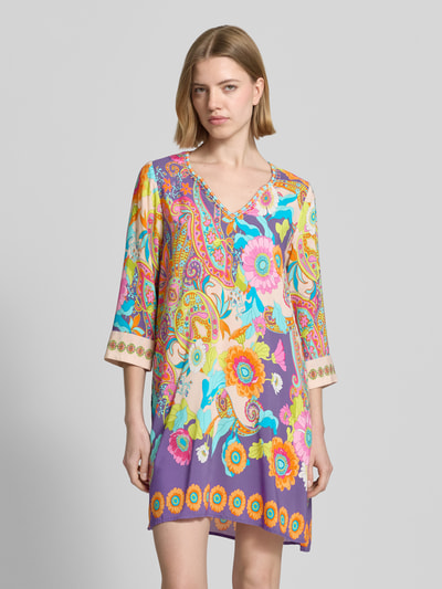 Frauenmodel trägt Knielanges Kleid aus Viskose mit Tunikakragen von Emily Van den Bergh, bunt, florales Muster, Straight Fit, Nahaufnahme Oberkörper.