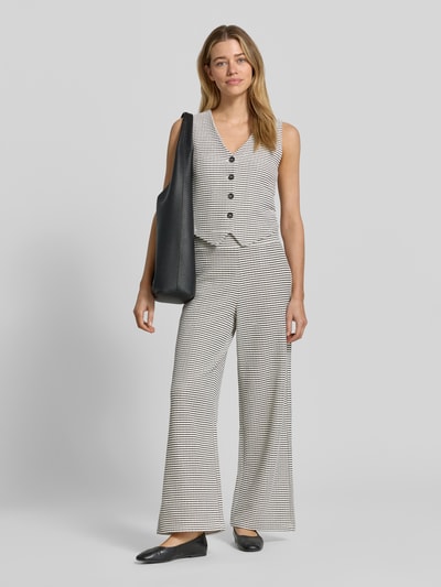 Frauenmodel trägt Slim Fit Weste aus Baumwoll-Mix von Tom Tailor Denim, Two Tone Optik, gestreift, Strick, einreihige Knopfleiste, Ganzkörperansicht von vorne.