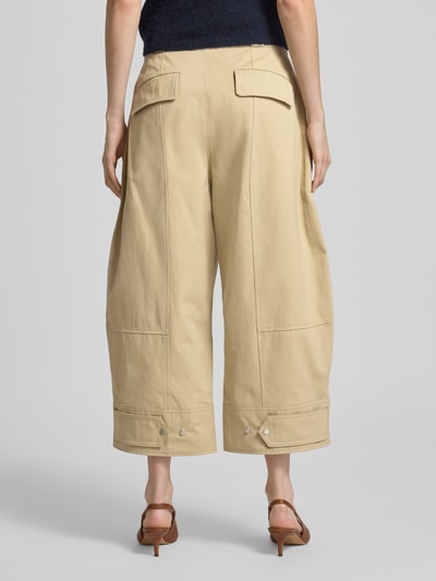 Vrouwenmodel draagt Loose Fit Chino uit puur katoen model 'Tikkara' van BOSS, effen kleuren, twill, high waist, verstelbare pijpboord, klepzak aan de achterkant, steekzakken, riemlussen, sluiting met haakjes- en ritssluiting, ganzebody van achteren.