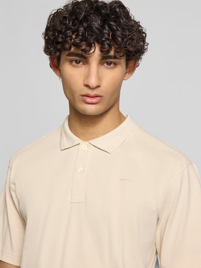 Männermodel trägt Regular Fit Poloshirt aus reiner Baumwolle Modell 'Core' von G-Star Raw in Beige mit Polokragen, Nahaufnahme Oberkörper.