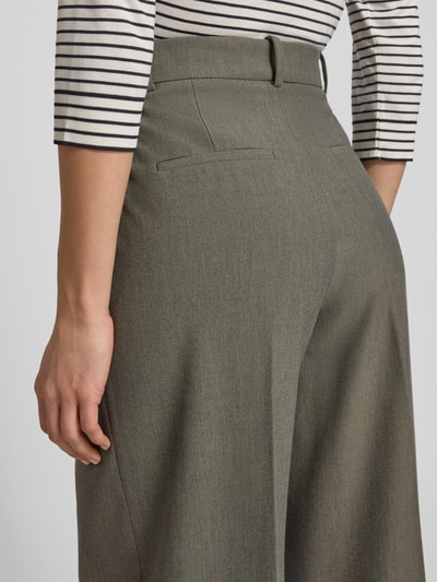 Frauenmodel trägt Wide Fit Bundfaltenhose mit Viskose-Anteil Modell 'Napoli' von Mango in Grau, feine Textur, Ganzkörperansicht Rückansicht. Damenmode-Kontext: elastischer Material-Mix, Bügelfalten, Haken- und Reißverschluss, Größe 36 Bundweite 39 cm, Innenbeinlänge 84 cm.