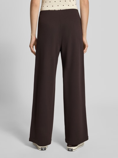 Frauenmodel trägt Weite Hose aus reiner Viskose Modell 'BREMEN' von ONLY in Dunkelbraun, glatte Textur, Damen Weite Hose von ONLY, Ganzkörperansicht Rückansicht.