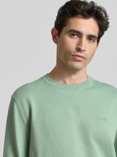Männermodel trägt Regular Fit Gebreide pullover uit puur katoen Model 'UPCAS' van BOSS in effen kleuren met labelstitching, nahaufnahme oberkörper.