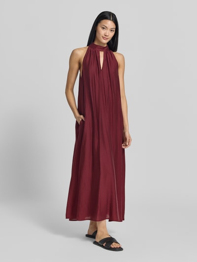 Frauenmodel trägt Midikleid aus Lyocell-Mix mit Cut Out von Jake*s Collection in Dunkelrot, A-Linie, Neckholder, fließende Textur, Ganzkörperansicht von vorne.