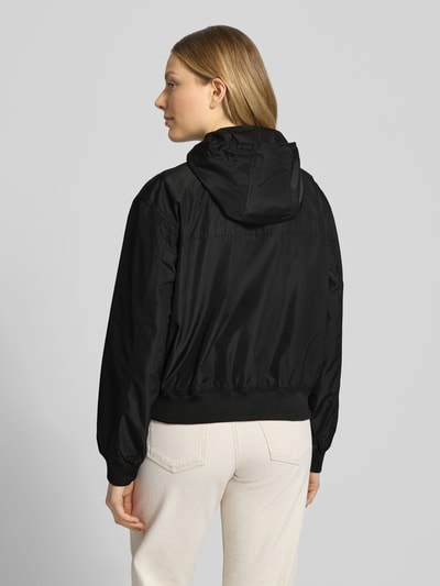 Frauenmodel trägt Regular Fit Blouson mit Kapuze von Tom Tailor Denim, Optik: Unifarben, wasserabweisend, seitliche Eingrifftaschen, Ganzkörperansicht Rückansicht.