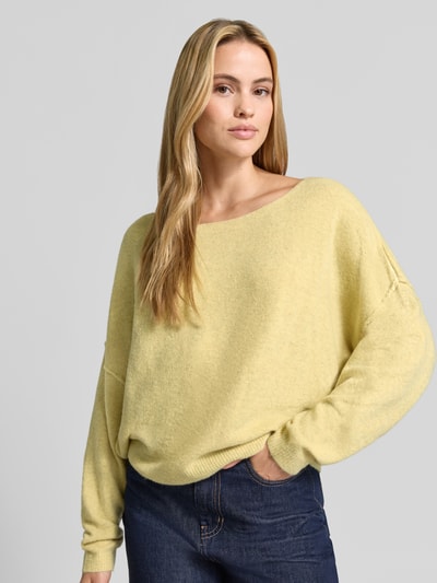 Frauenmodel trägt Relaxed Fit Strickpullover aus Material-Mix mit Leinen-Anteil von American Vintage in Gelb, gerippte Abschlüsse, überschnittene Schultern, Rundhalsausschnitt, Damen Strickpullover, Ganzkörperansicht von vorne.