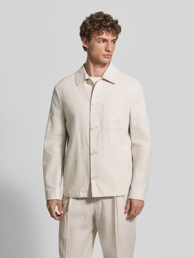 Männermodel trägt Relaxed Fit Overshirt aus Leinen-Baumwoll-Mix mit Kentkragen von MCNEAL, Knopfleiste, Brusttaschen, Sportmanschetten, Rückenlänge 69 cm, cremefarbener Stoff mit weicher Textur, Ganzkörperansicht von vorne.
