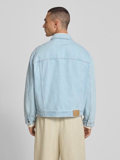 Männermodel trägt Jeansjacke aus reiner Baumwolle von MAISON KITSUNÉ in Hellblau mit Umlegekragen, gerade Passform, Rückansicht.