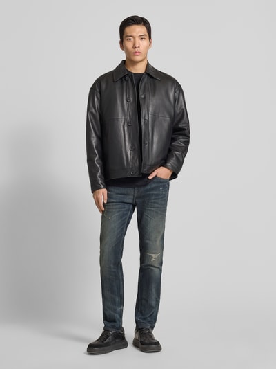 Männermodel trägt Slim Fit Jeans aus Baumwoll-Mix Modell 'DELAWARE BO IMAGE' von BOSS Orange in Used-Look, unifarben, Ganzkörperansicht von vorne.