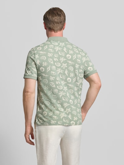 Männermodel trägt Regular Fit Poloshirt mit Allover-Motiv-Print von Gant in Hellgrün, Reine Baumwolle, Kurzärmelig, Rückenlänge 68 cm, Ganzkörperansicht Rückansicht.