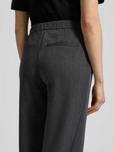 Männermodel trägt Stoffhose mit elastischem Bund Modell 'Melane' von OPUS, ciemnoszary materiał z wiskozą, luźny krój, widok z tyłu, detal tył.