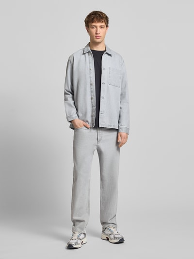 Männermodel trägt Loose Fit Jeans aus reiner Baumwolle Modell 'RUNNE' von Marc O'Polo Denim in heller Denim-Optik, 5-Pocket-Design, Ganzkörperansicht von vorne.