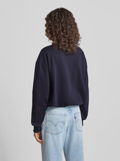 Männermodel trägt Sweatshirt mit Logo-Stitching Modell 'Jana' von LeGer by Lena Gercke, bawełna, luźny krój, elastyczne wykończenia, ujęcie całej sylwetki z tyłu
