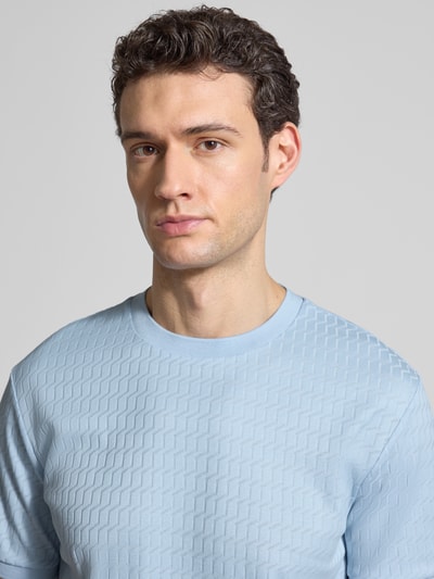 Männermodel trägt Regular Fit T-Shirt aus reiner Baumwolle Modell 'THOMSON' von BOSS in Hellblau mit feinem Strukturmuster, Nahaufnahme Oberkörper.