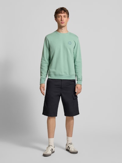 Männermodel trägt Regular Fit Pullover mit Logo-Stitching Modell 'Kane' von Blend in Mintgrün, Baumwoll-Mix, Rundhalsausschnitt, Ganzkörperansicht von vorne.