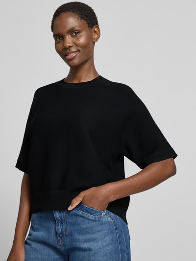 Frauenmodel trägt schwarzen Relaxed Fit Pullover aus Viskose-Mix Modell 'Thamira' von MSCH Copenhagen, Strick-Optik, Nahaufnahme Oberkörper.