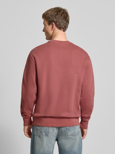 Männermodel trägt Sweatshirt mit Logo-Stitching und Rundhalsausschnitt von Levi's®, lockerer Schnitt, gewachste Baumwolle, Ganzkörperansicht Rückansicht.