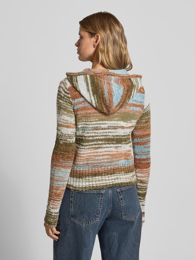 Vrouwenmodel draagt gebreid jack met capuchon Model 'CINNAMON' van DAISY STREET, regular fit, ruglengte maat S 52 cm, mouwlengte 65 cm, tweewegritssluiting, meerkleurig streeppatroon, grof gebreide textuur, geheelzicht achteraan.