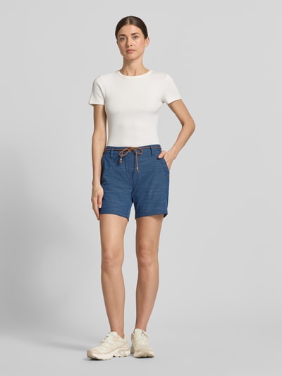 Frauenmodel trägt Bermudas mit Bindegürtel und Eingrifftaschen von G.I.G.A. DX, blaue Farbe, Baumwoll-Mix mit Stretch-Anteil, Ganzkörperansicht von vorne.