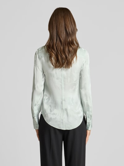 Frauenmodel trägt Bluse aus Viskose mit abgerundetem Saum von Calvin Klein Womenswear in hellem Grün, Kentkragen, Knopfleiste, Rückenlänge 65 cm, Ärmellänge 63 cm, Ganzkörperansicht Rückansicht.