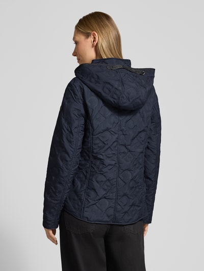 Frauenmodel trägt Jacke mit Stehkragen und Reißverschlusstaschen von Gil Bret in Dunkelblau, strukturierte Baumwolle, taillierter Schnitt, Kapuze, Ganzkörperansicht Rückansicht.