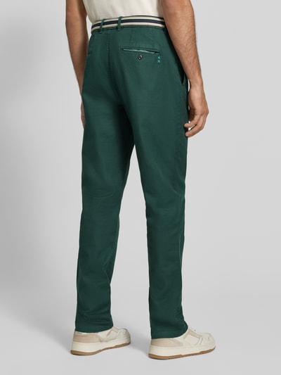 Männermodel trägt Hose mit Gürtel Modell 'WARREN' von Scotch & Soda in Dunkelgrün, Baumwoll-Elasthan-Mix, Rückansicht Ganzkörperansicht.
