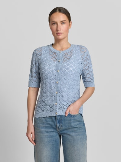 Kobiece model prezentuje Regular Fit Strickjacke aus reiner Baumwolle Modell 'SOFIA' od Selected Femme, jasnoniebieska ażurowa dzianina, okrągły dekolt, krój regular fit, przód z guzikami, prosty rękaw 1/2, widok całej sylwetki z przodu.