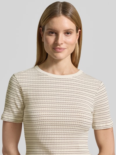 Kobiece model nosi damski t-shirt z mieszanki bawełny z dodatkiem streczu, krój slim fit, model 'Soleili' od OPUS, okrągły dekolt, długość tyłu w rozmiarze 36: 55 cm, jasny kolor, delikatny wzór w paski, tekstura prążkowana, widok z przodu, zbliżenie na górną część ciała.