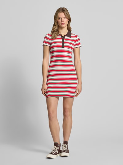 Frauenmodel trägt Polokleid aus Viskose-Mix mit kurzer Knopfleiste Modell 'Elenia' von LeGer by Lena Gercke in Rot-Weiß-Streifen, Körpernaher-Schnitt, Minikleid, Polokragen, Ganzkörperansicht von vorne. Rückenlänge bei Größe 36: 83 cm, Brustweite 33 cm, Ärmellänge 19 cm.