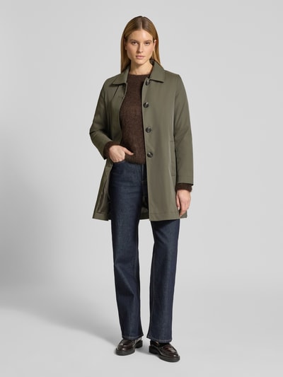 Frauenmodel trägt Mantel mit verdeckter Knopfleiste und Eingrifftaschen von Christian Berg Woman Selection in Olivgrün, Gerader-Schnitt, Kentkragen, Ganzkörperansicht von vorne, Kontext: Rückenlänge 87 cm, Schulterbreite 40 cm, Brustweite 54 cm, Ärmellänge 62 cm bei Größe 36.